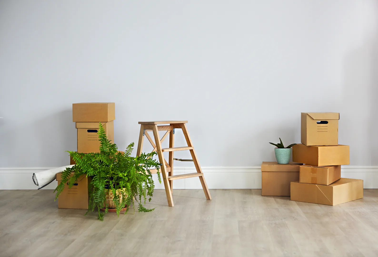 Cardboard moving boxes stacked in an empty apartment ready for an international family relocation